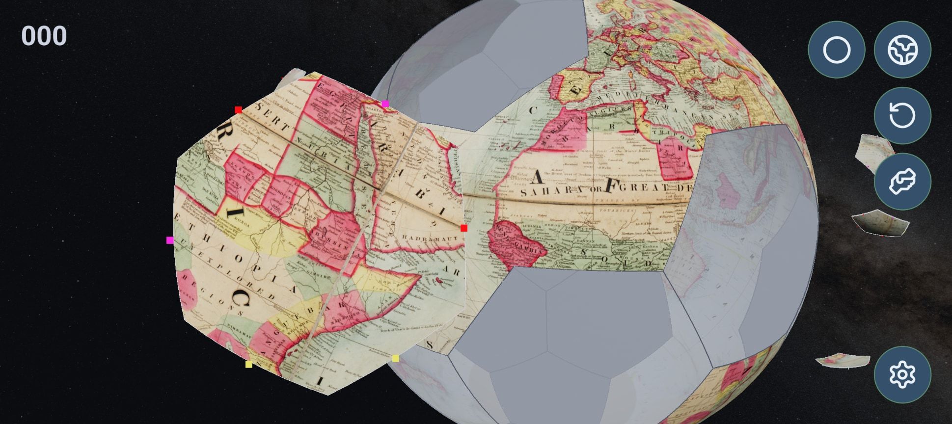 Colton's map further along: Africa and the Atlantic covering half the grey sphere, the Sahara on the piece being placed, and loose pieces scattered round it.